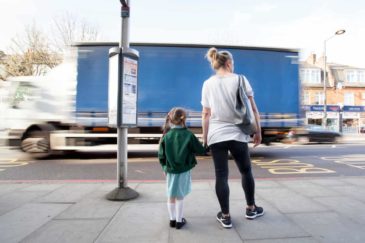 photo of mother and daughter holding hands in a big city