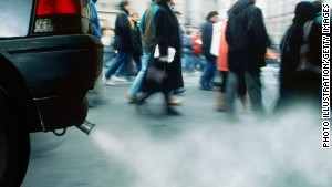 People walking on city street, car exhaust emitting smoke, low angle
